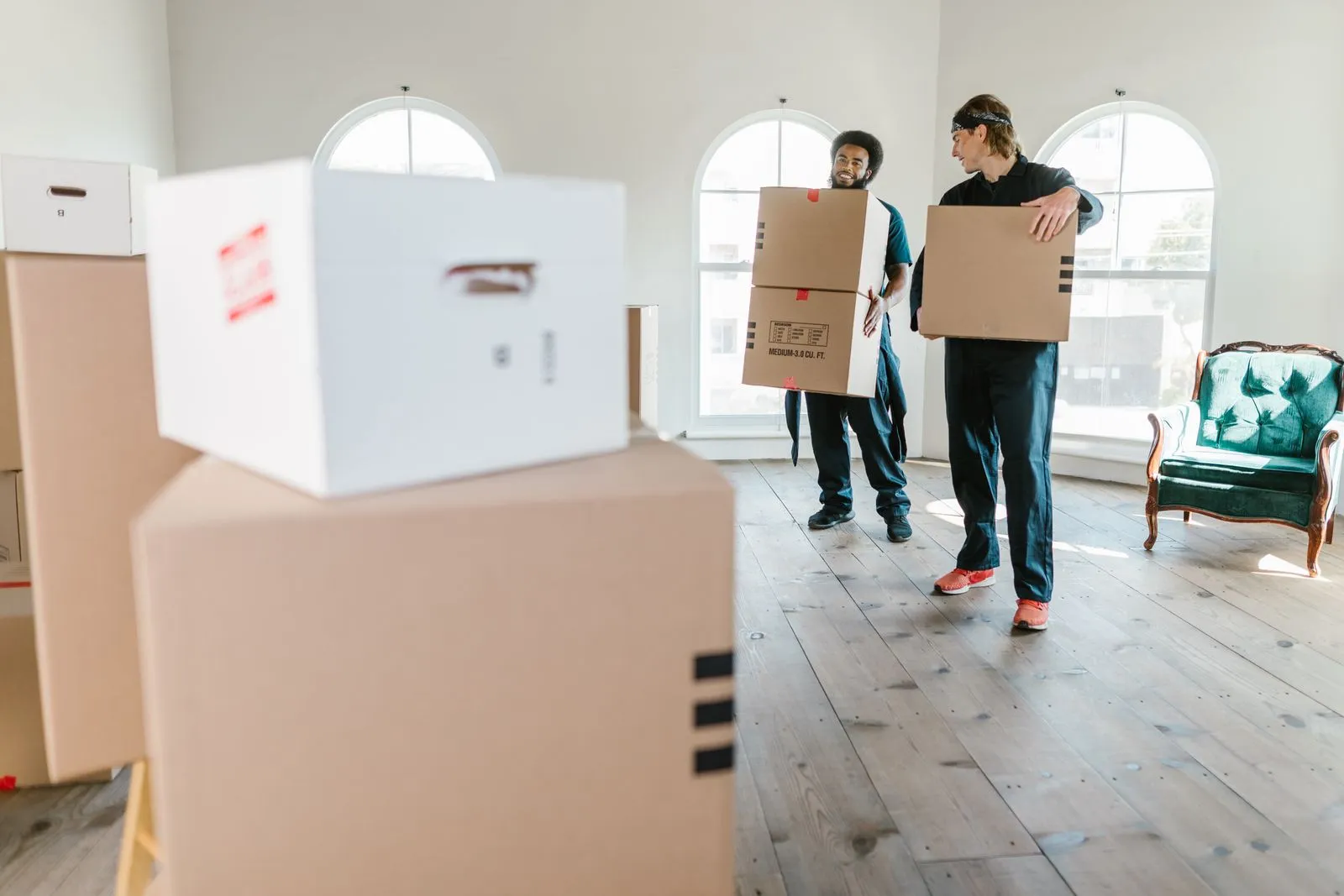 Deux déménageurs professionnels transportant des cartons dans un appartement lumineux à Casablanca
